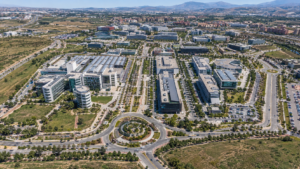 Vista aérea de un parque tecnológico y polígono industrial moderno en Granada con montañas al fondo.